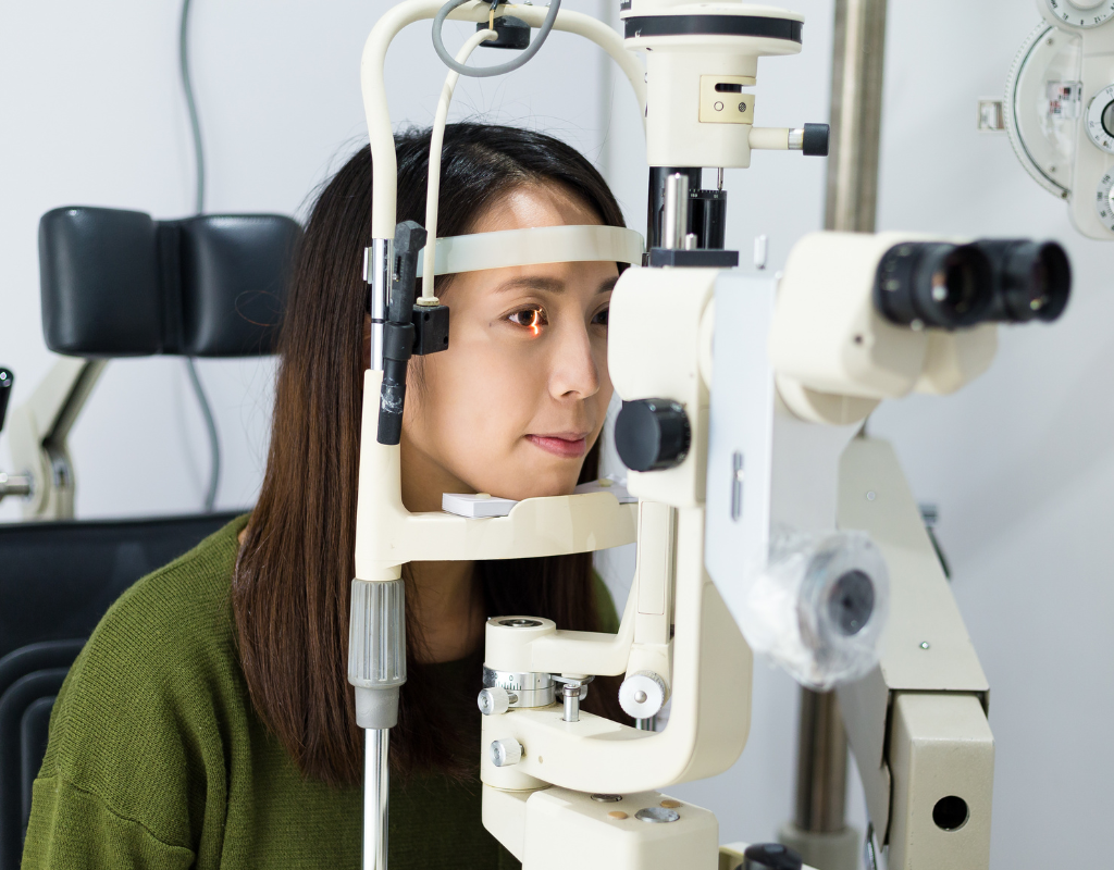 Patient undergoing an eye examination using a slit lamp device.