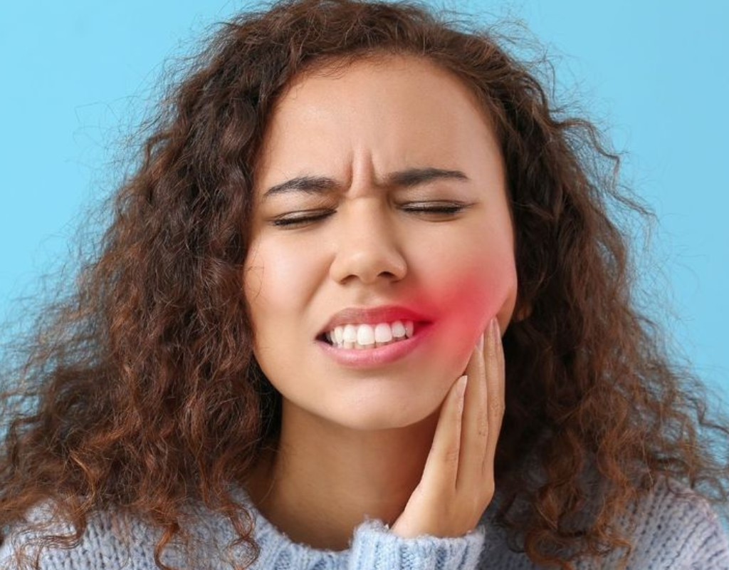 Woman holding her jaw in pain, indicating a toothache.