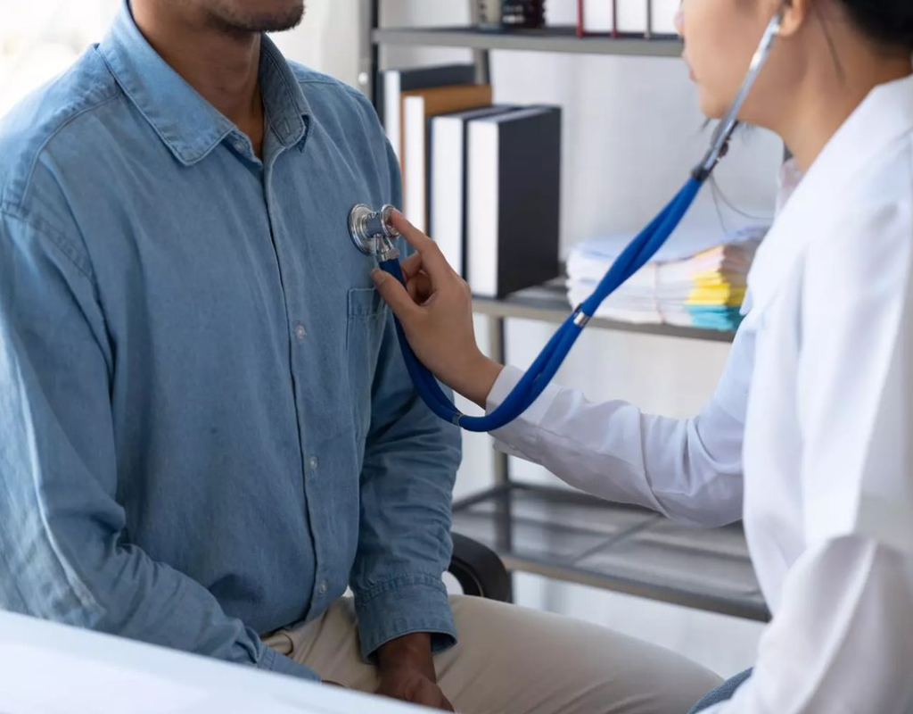 Female doctor using a stethoscope to listen to a patient’s heart and lungs.